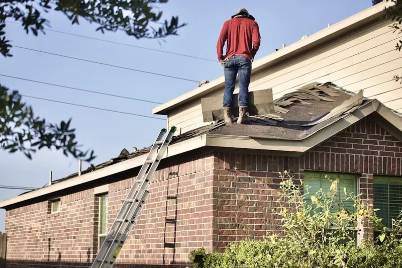 Professional roofer working on a residential roof in Fair Lakes